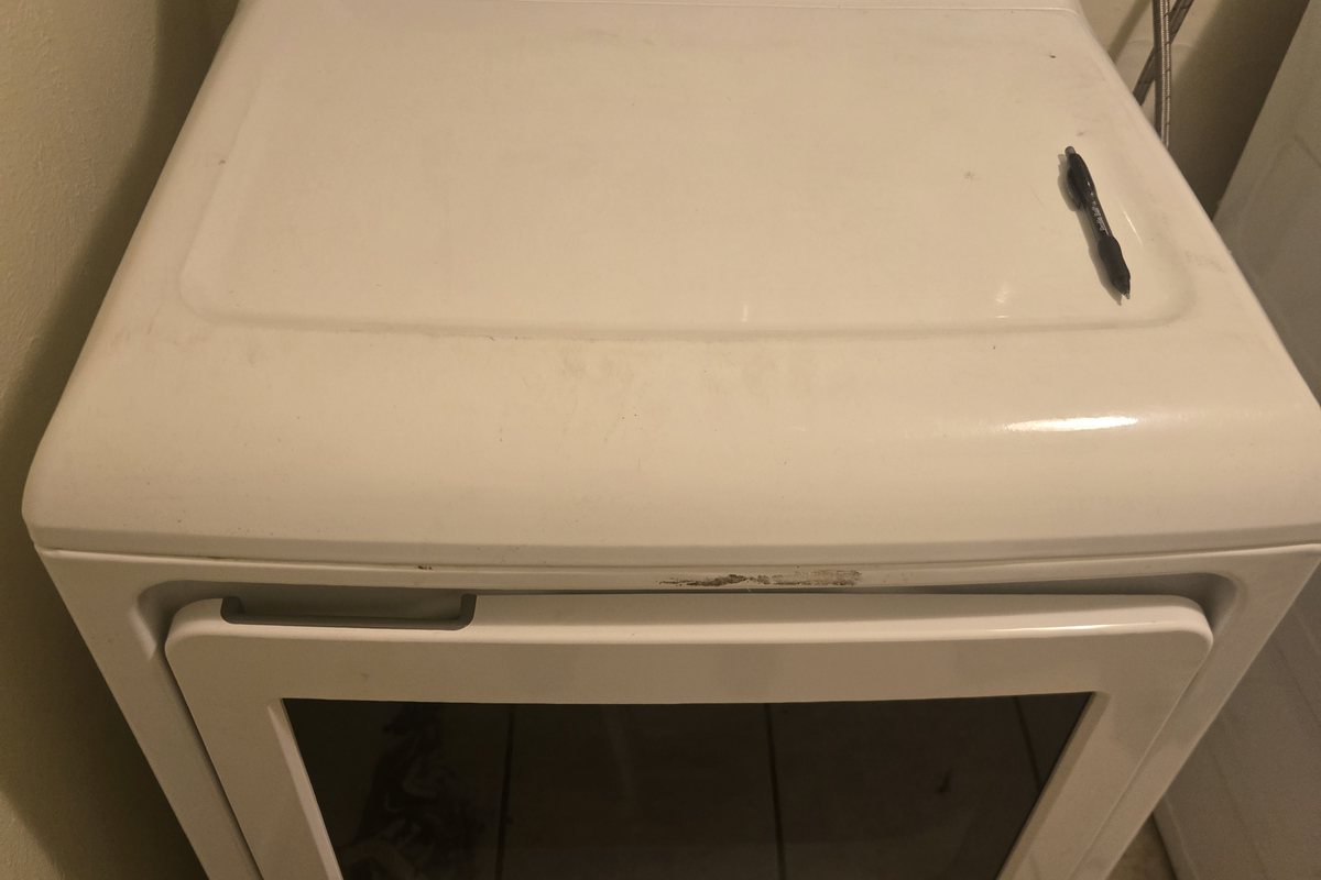 Clean white dryer with the door open, serviced on a DLT call
