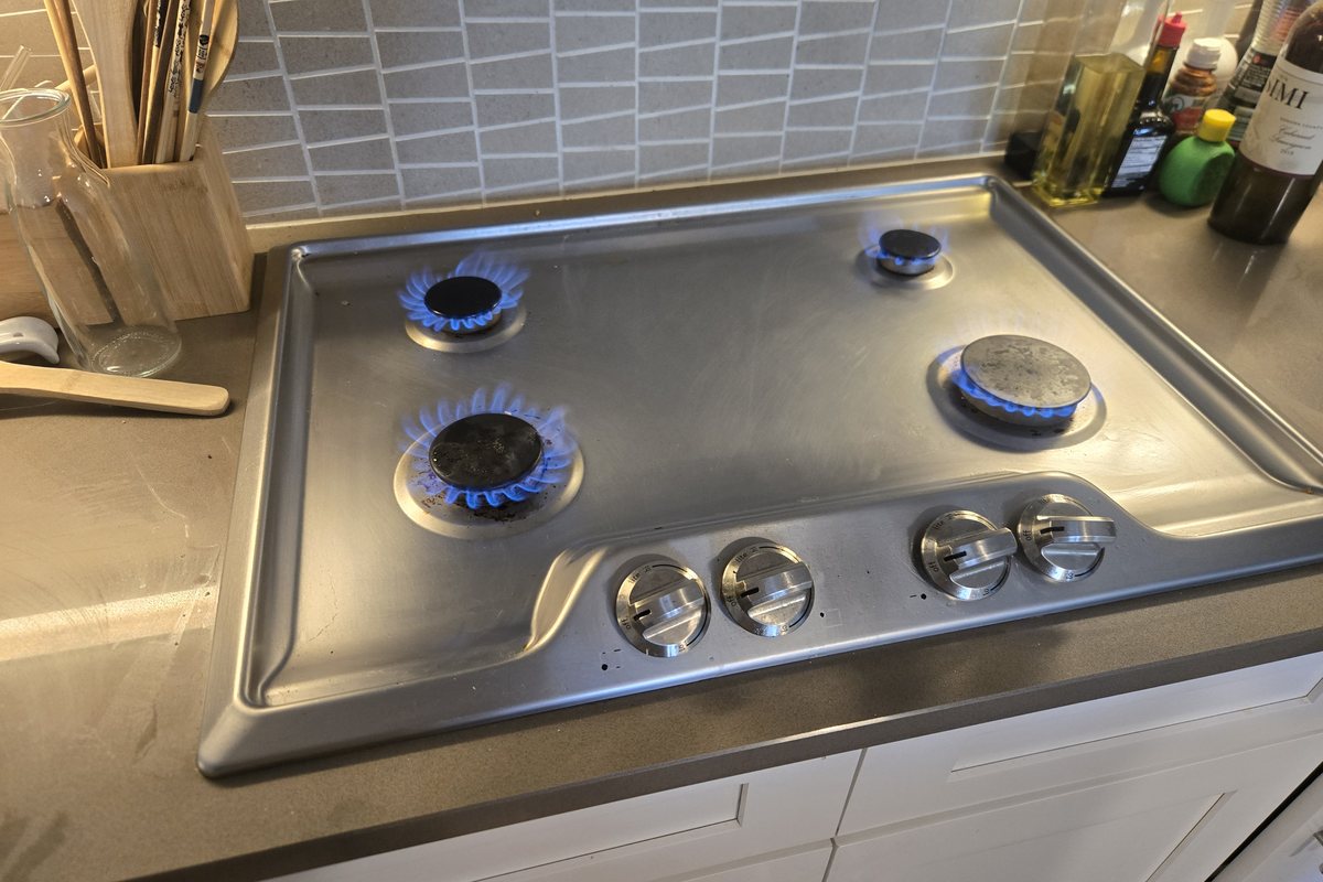 Gas cooktop with burners lit after a DLT range repair