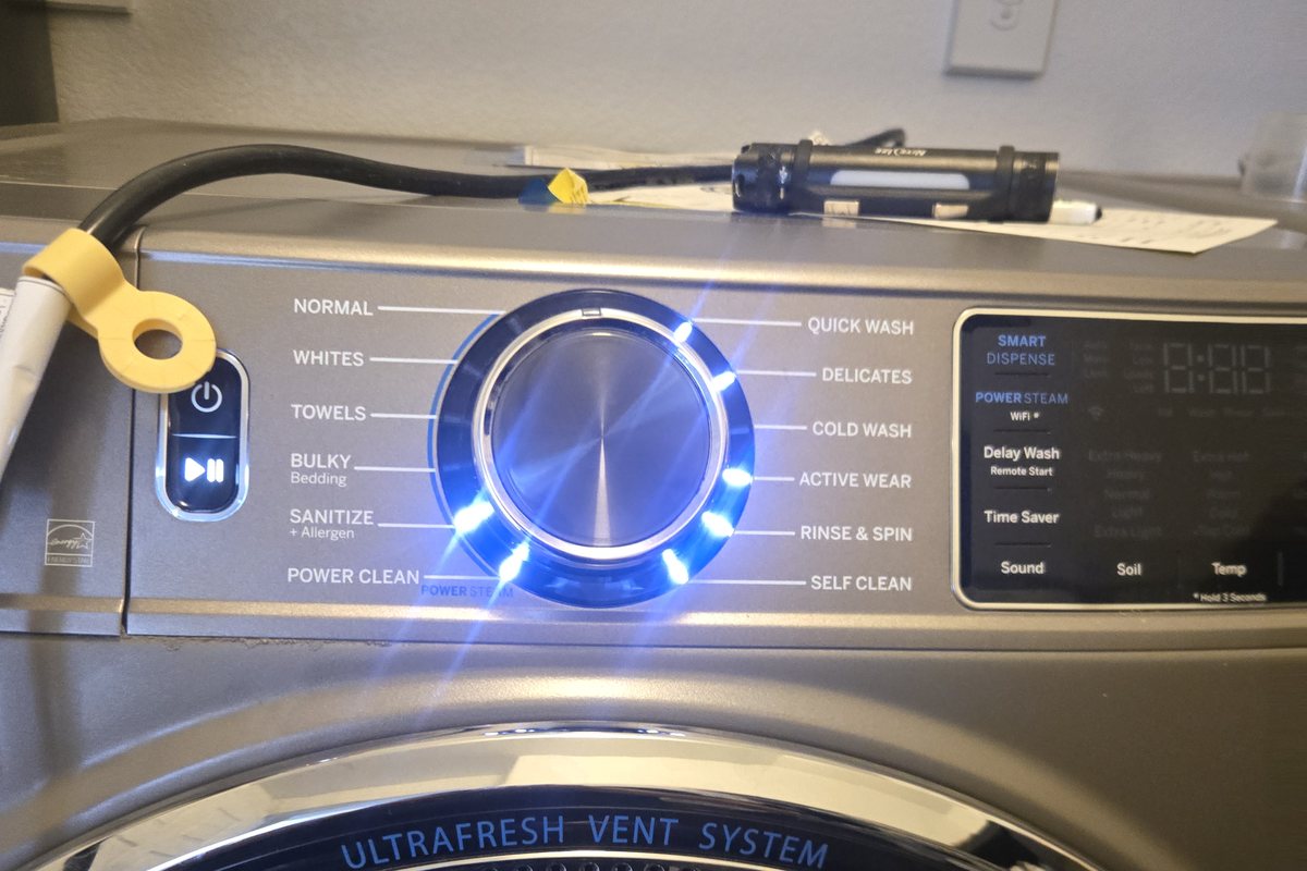 Front-load washer with its control dial lit up after a completed repair