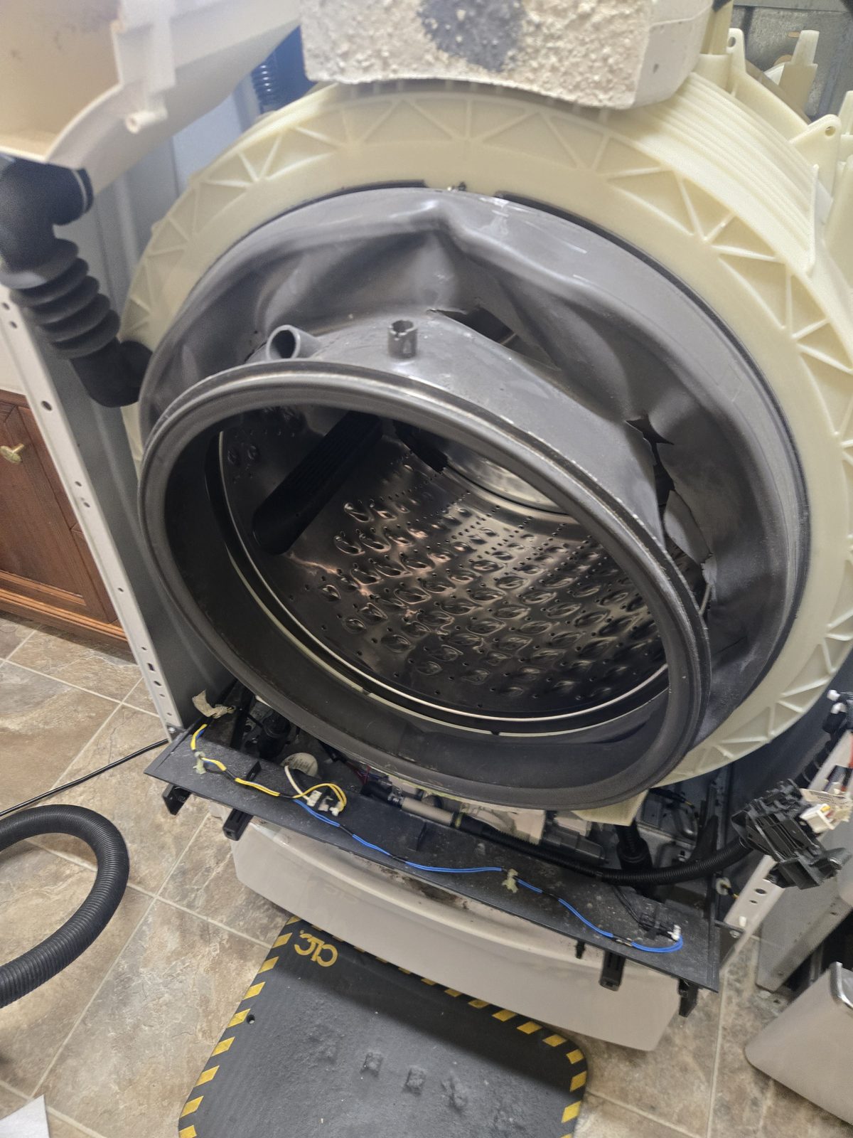 Front-load washer opened up with the outer tub and stainless drum exposed for inspection